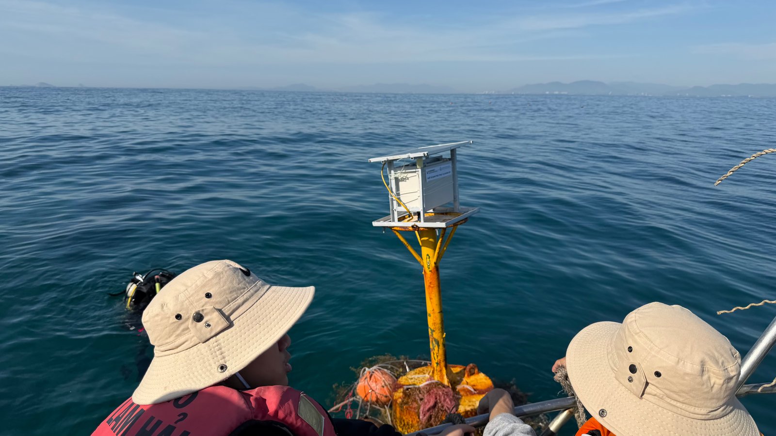 Deployed solar telemetry station on marine beacon with diver